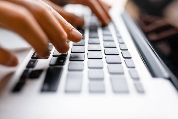 istock Hands using laptop type on keyboard, simple clean close up image with sun flare 812300810