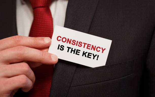 istock Businessman putting a card with text Consistency is the key in the pocket 812371524