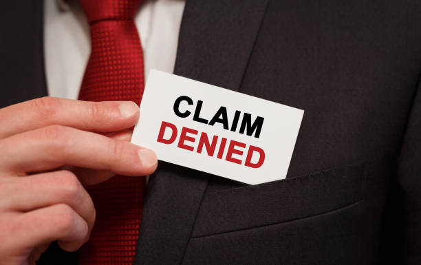 Businessman putting a card with text Claim Denied in the pocket stock photo