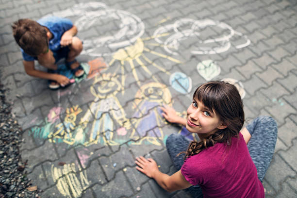 istock Kids drawing with chalk on sidewalk 812395674