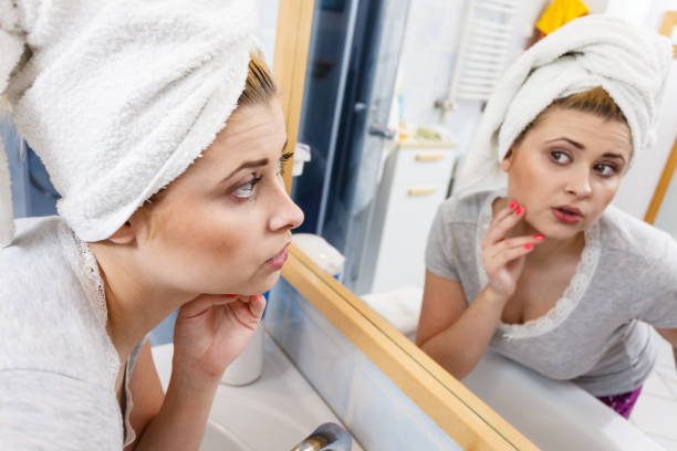 istock Woman looking at her reflection in mirror 812401800