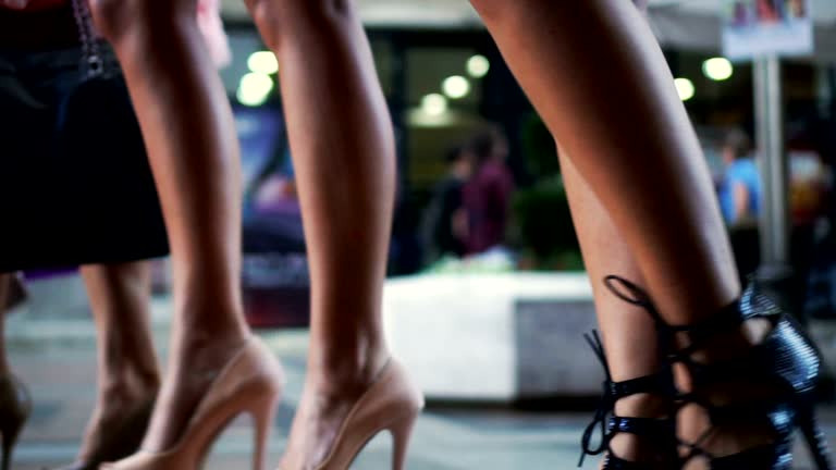 Close-up video of young women walking on high heels in the city.