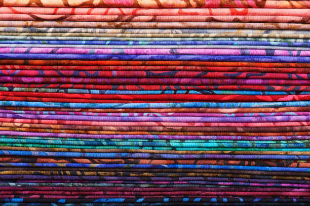 stack of colorful batik fabrics as a vibrant background image - patch textile stack heap imagens e fotografias de stock