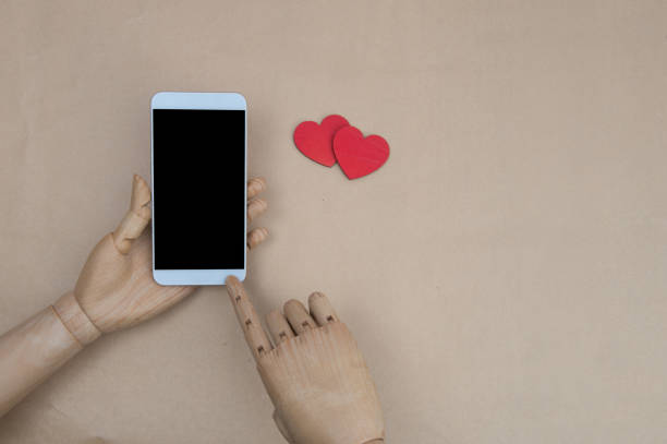 istock Valentine day internet messaging concept, online connection holiday background with copy space. Mobile phone on rustic wood with couple of red hearts, top view. Card and advertising mockup 812407472