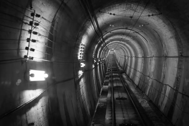istock Underground facility with a big tunnel leading deep down. Abstract architecture black and white concept background. Soft and select focus. 812410990