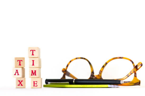 istock Wood Block Letters Spelling TAX TIME, Glasses, Pen, Notebook 812416990