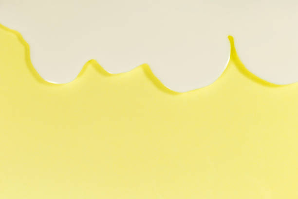 istock White cream flow on the soft yellow background. 812419592