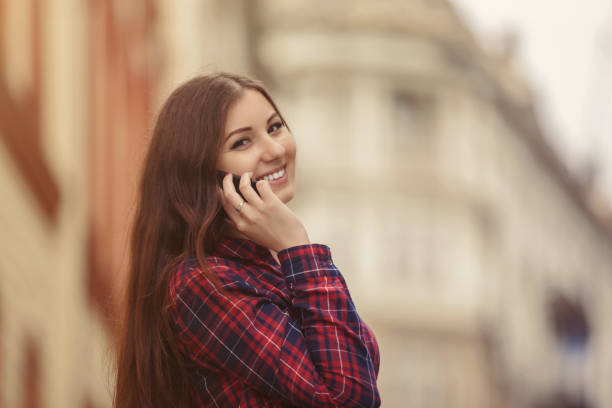 istock Young woman smiling and talking on mobile phone 812423476