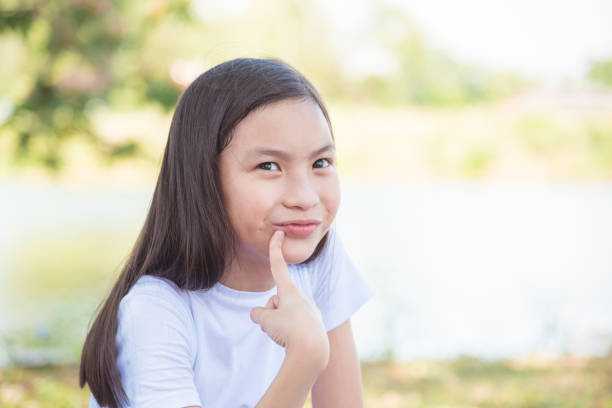 istock Young girl sitting in park 812425632