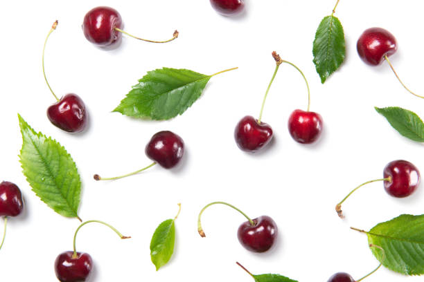 istock Ripe cherry berries and cherry leaves pattern isolated on white background, top view 812425880