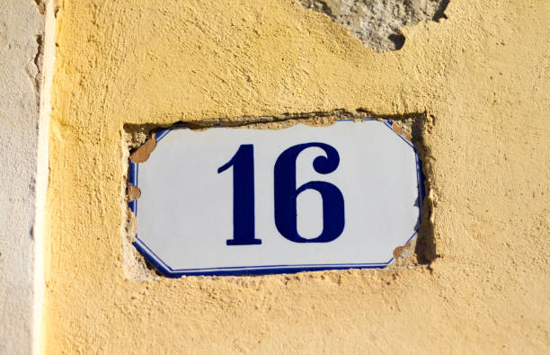 istock Number 16 Street Address Tile On Old Pastel Yellow Wall 812454936