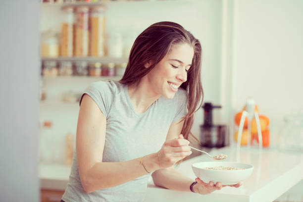 istock Young  woman breakfast cereals in the kitchen 812455412