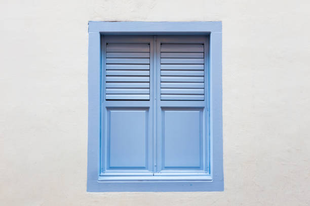 istock Blue wooden window is classic vintage style on white cement wall background. 812457094