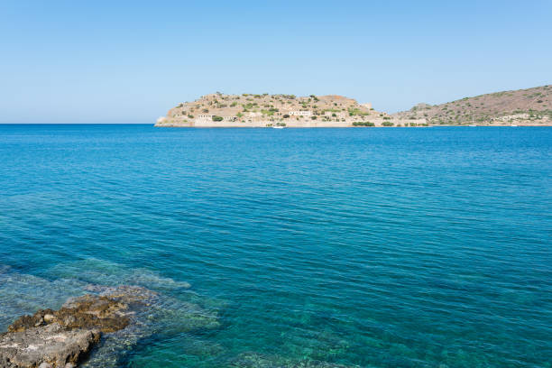 View of the island of Spinalonga with calm sea. Here were isolated lepers, humans with the Hansen's desease, gulf of Elounda, Crete, Greece.