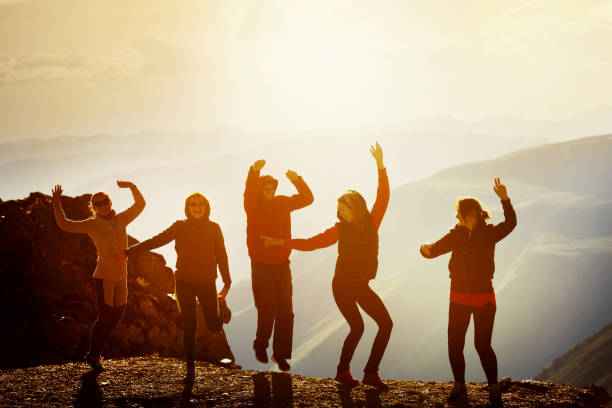 istock Happy friends dancing on sunset mountain 812470456