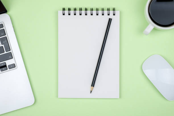 istock Minimal workplace with laptop and blank notepad on colored background. Top view. Flat lay 812473944