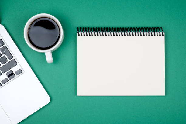 istock Designer office desk with blank notebook page and laptop computer. Top view, flat lay 812473992