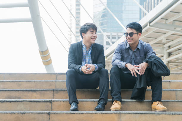 istock Handsome young businessman sitting on the stairs talking about the project. 812479134