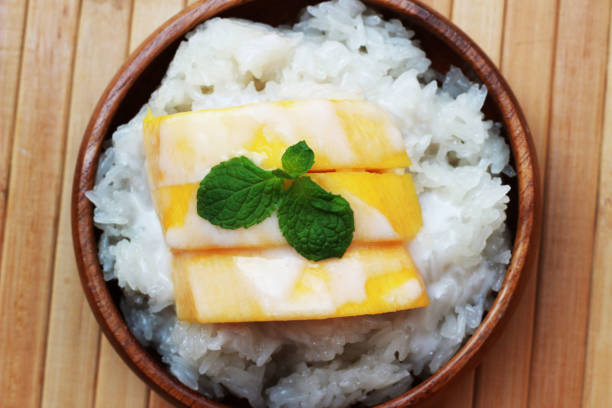 istock Mango sticky rice is put in a wooden container placed on a brown wooden table 812484454