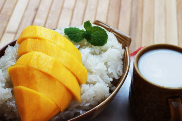 istock Mango sticky rice is put in a wooden container placed on a brown wooden table 812484530