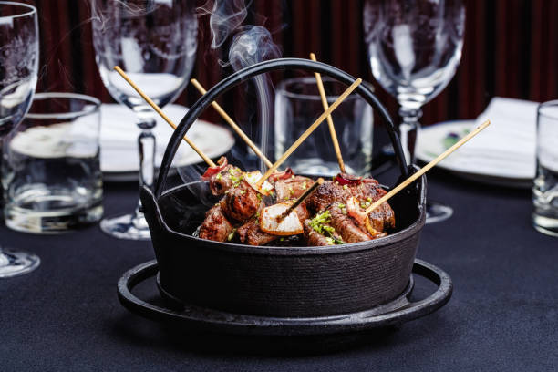 Meat on skewers smoks in a brazier