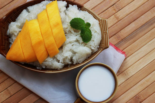 istock Mango sticky rice is put in a wooden container placed on a brown wooden table 812484894