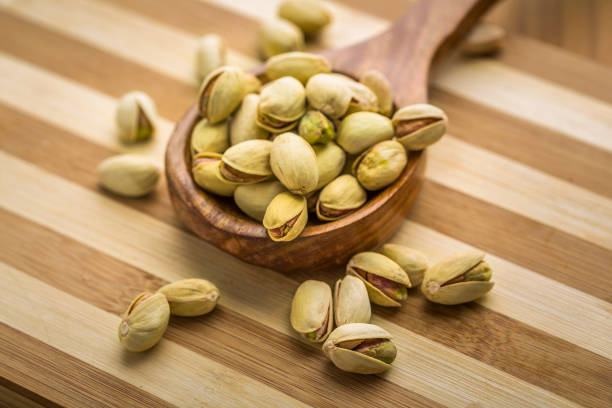 pistachios pistachios in a wooden spoon singh stock pictures, royalty-free photos & images