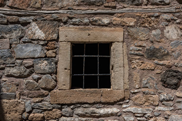 Ancient arched church window and stone wall.