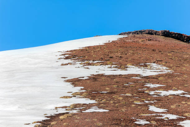 istock snow on lava stone on mountain etna 812542894