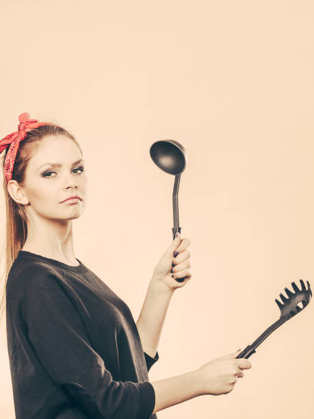 istock Retro styled woman having fun with kitchen accessories. 812580034