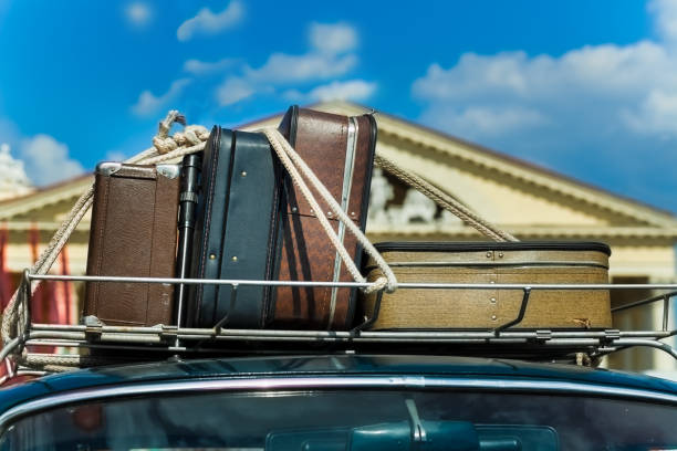 Vintage suitcases on the roof of the trunk of a car. stock photo