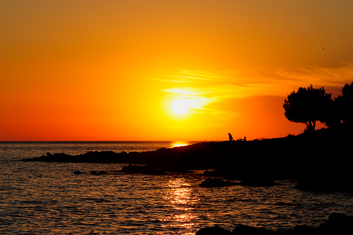 Silhouette of a Scherlock and Budha over sunset on the coast