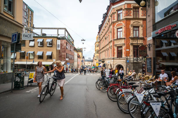 Stockholm, Sweden - August 5, 2016: Bicycles parked on Stockholm street.  People shopping, sightseeing and relaxing in cafes.