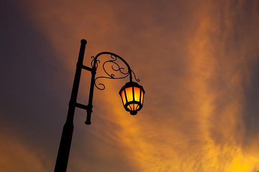 Vintage illuminated street lamps orange light with sunset cloud orange color background