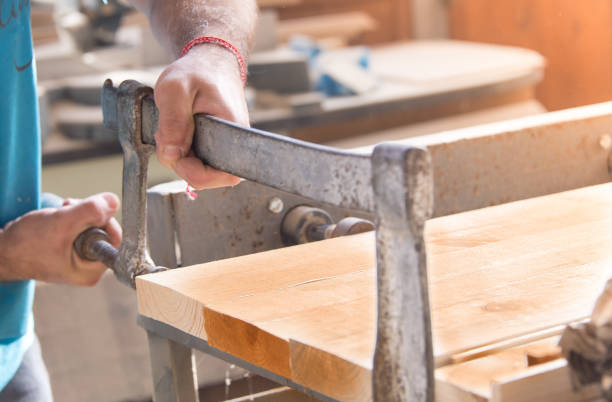 istock Carpenter tightened boards with carpentry clamp. 812652636