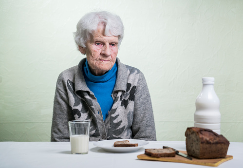 Old woman at the poorly laid table