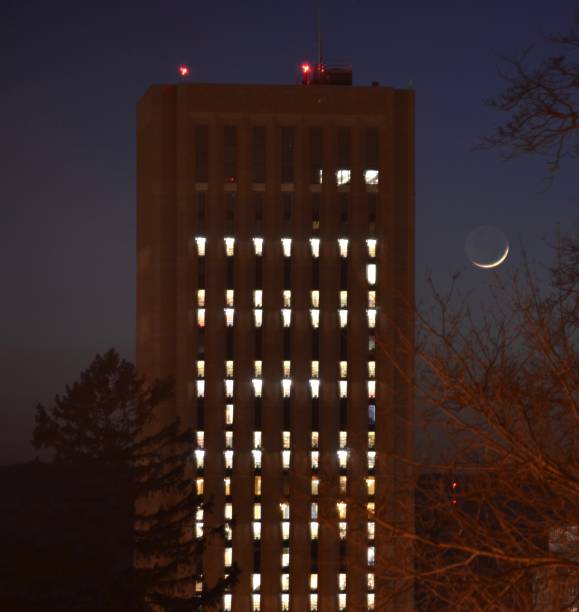 Moonset by Dubois Library The crescent moon dips into the rolling hills of western Massachusetts behind Dubois Library, one of the tallest Libraries in the world. university of massachusetts amherst stock pictures, royalty-free photos & images