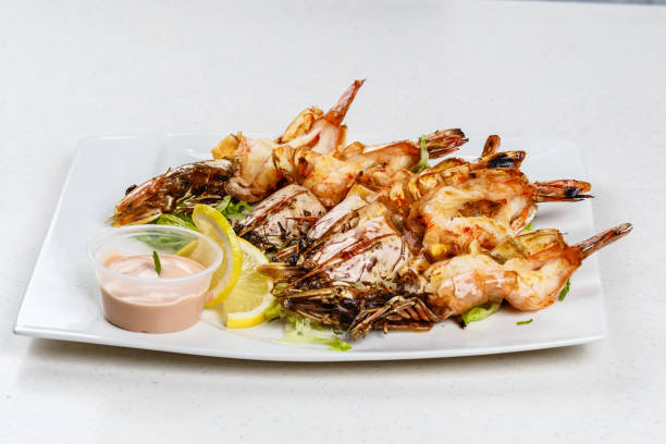 istock Grilled tiger prawns served with leafs and lemon 812677340