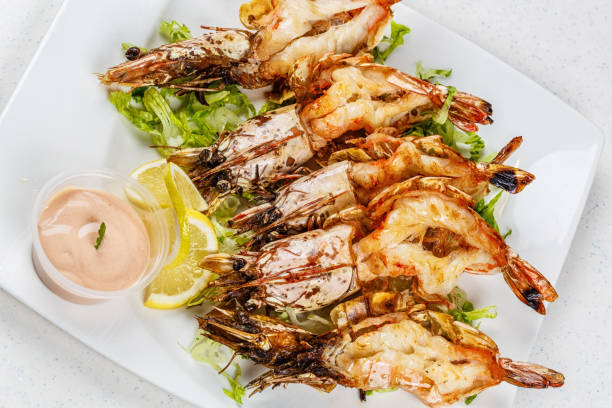 istock Grilled tiger prawns served with leafs and lemon 812677862