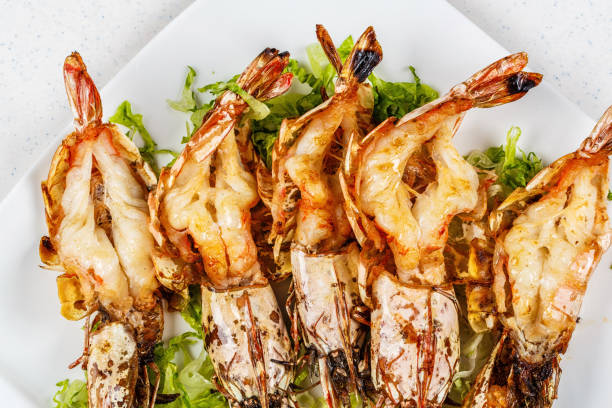 istock Grilled tiger prawns served with leafs and lemon 812678264