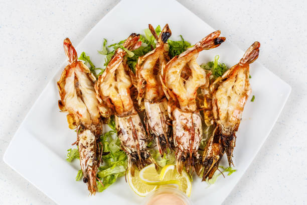 Grilled tiger prawns served with leafs and lemon