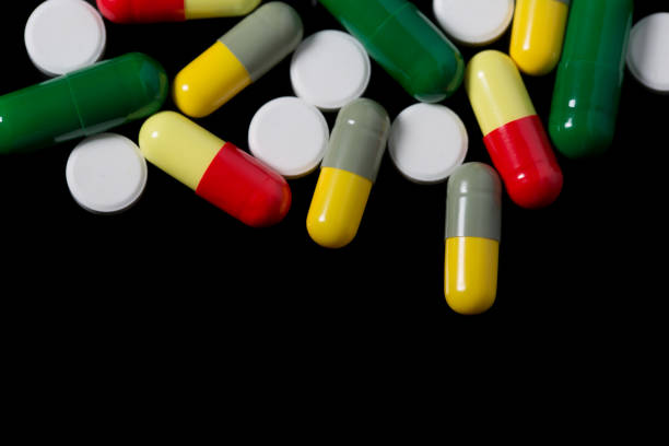 istock Assorted pharmaceutical medicine pills, tablets and capsules over black background 812703572