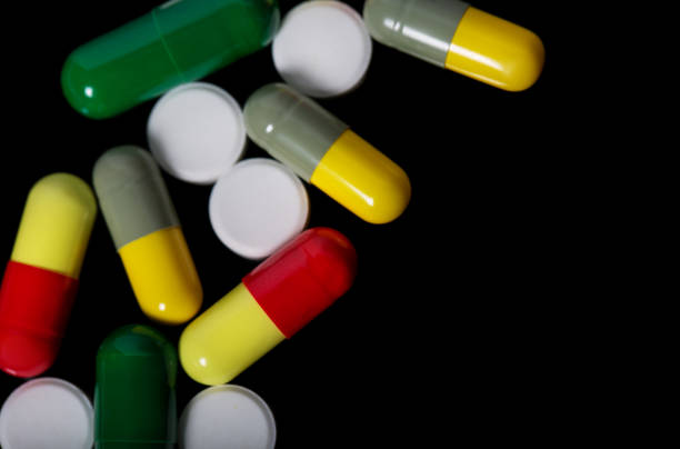 istock Assorted pharmaceutical medicine pills, tablets and capsules over black background 812703676