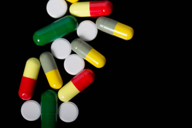 istock Assorted pharmaceutical medicine pills, tablets and capsules over black background 812703762