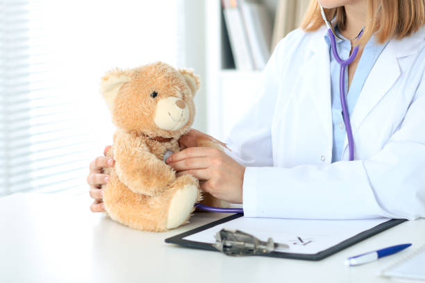 istock Female doctor examining a Teddy bear  patient by stethoscope. 812704166