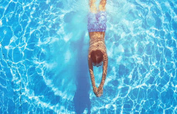 istock Happy boy diving in the swimming pool 812710410