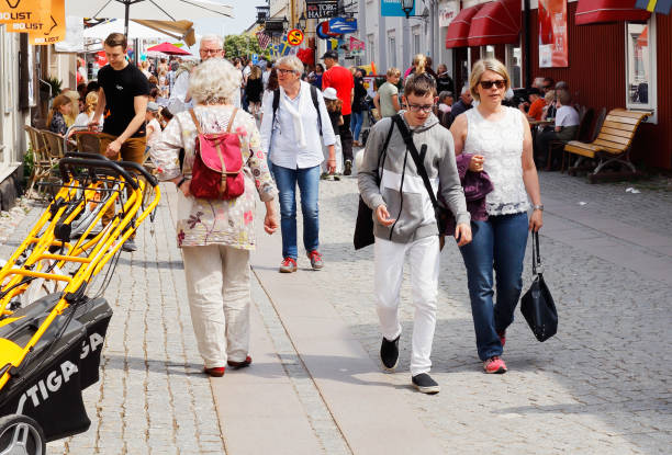 People walking Mariefred, Sweden - June 10, 2017: People walking the main street Storgatan in the Swedish small town Mariefred. mariefred stock pictures, royalty-free photos & images