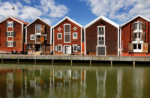 Hudiksvall, Sweden - July 5, 2017: Old red warehouses built of wood next to the water.