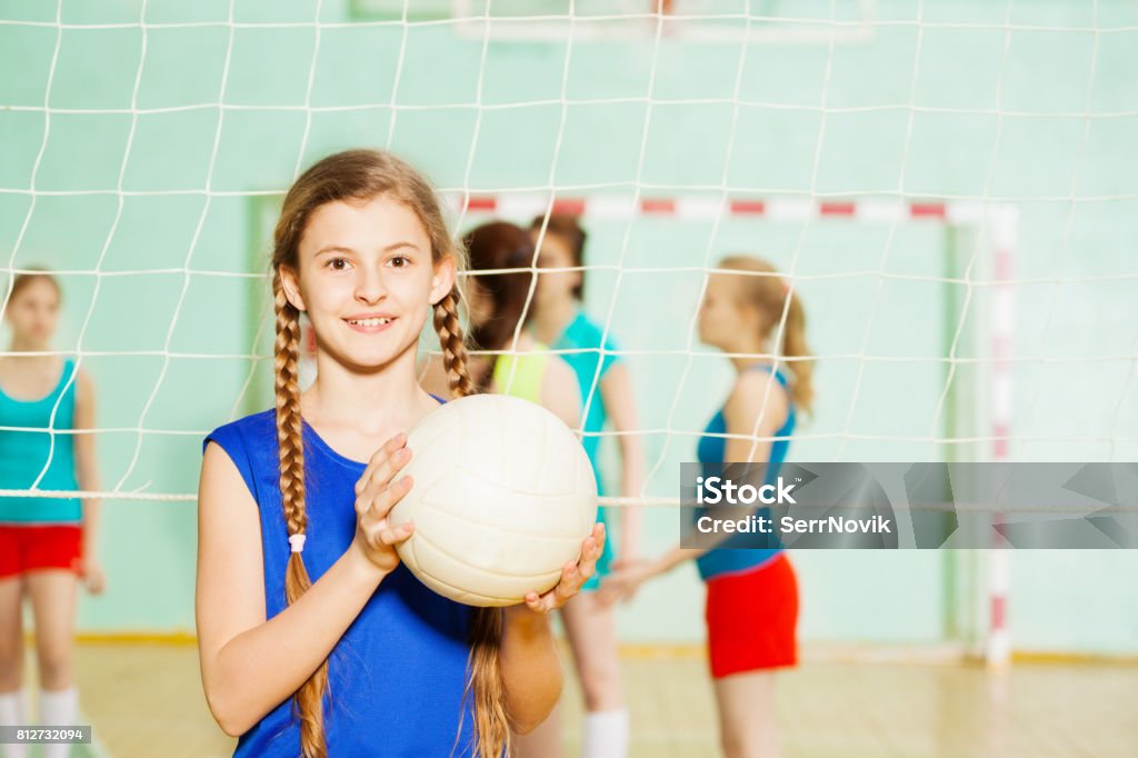 Chica adolescente con la bola de voleibol en el pabellón de deportes - Foto de stock de Juego de vóleibol libre de derechos