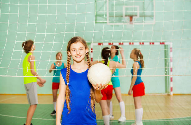 adolescente heureuse avec balle au cours de la formation - sport volleyball high school student teenager photos et images de collection